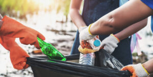 recycling bin with bottles being placed inside 