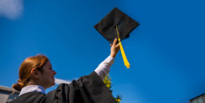 girl holding graduation cap in hand